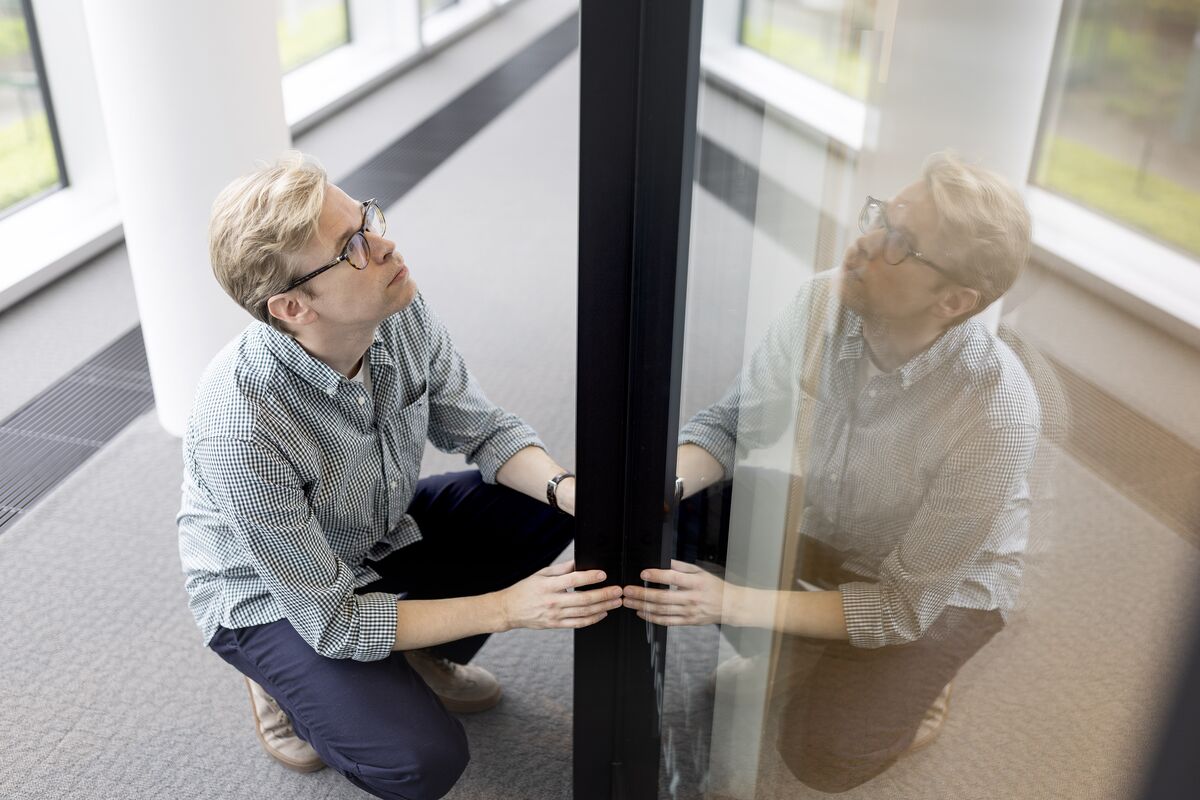 Homme avec VERRE tenant un PROFIL en aluminium noir.